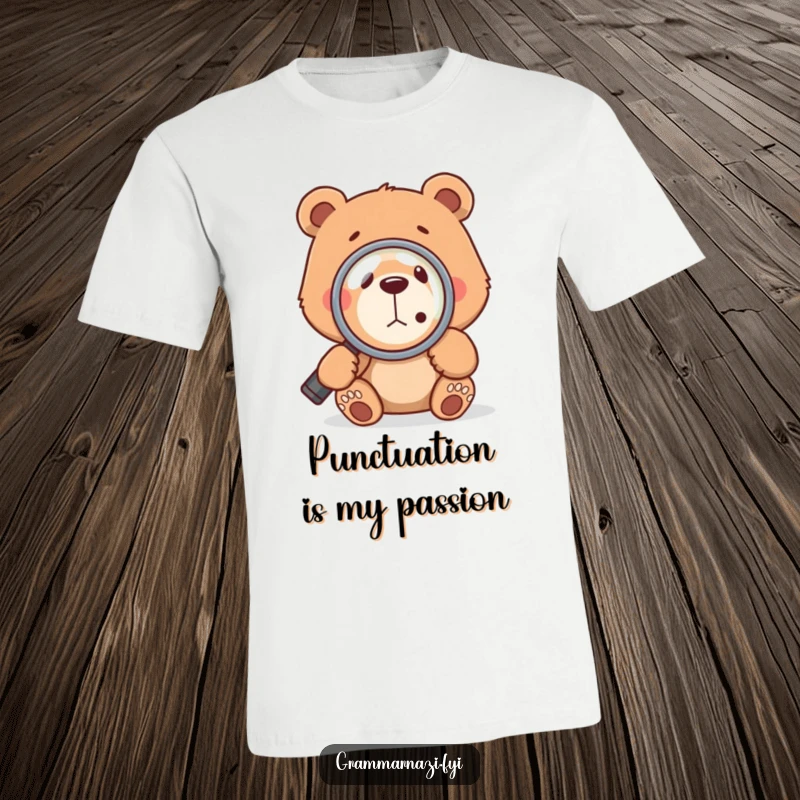 Funny bear character using a magnifying glass to closely examine a small comma, highlighting a passion for grammar on a t-shirt.